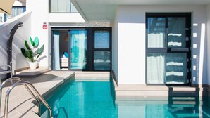 Un hotel moderno con piscina, zona de estar al aire libre techada y una amplia puerta de cristal corredera.