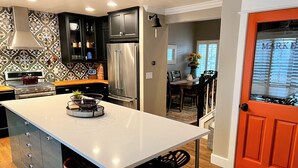 A modern kitchen with a large island, stainless steel appliances, and dark cabinetry. - Fully Remodeled Home In Boulder County (Superior)