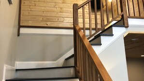 Un escalier en bois avec une rampe, menant à l’étage supérieur.