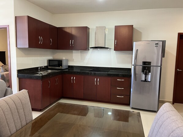 Fridge, microwave, coffee/tea maker, cookware/dishes/utensils