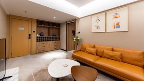 A modern hotel lobby with a leather sofa, a white coffee table, and a wooden cabinet with a grid pattern. - Hongsheng Hotel (Yuxi)