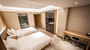 A modern hotel room with two beds, a desk, and a seating area. - Hongsheng Hotel (Yuxi)