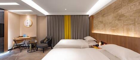 A hotel room with two beds, a desk, a chair, and a large wall mural.