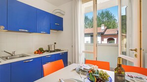 Eine moderne Küche mit blauen Schränken, einem Esstisch gedeckt mit Tellern, Gläsern und einer Weinflasche.