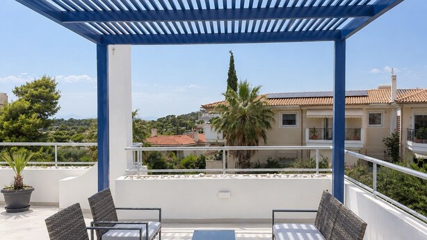 A covered outdoor seating area with a pergola, a table, and two chairs.