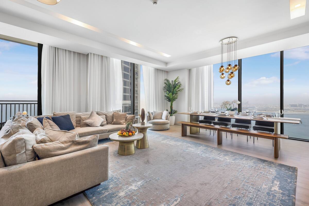 Een moderne woonkamer met een bank, salontafel en eethoek.