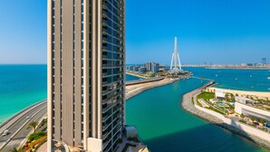 A high-rise building with a view of a coastal area, including a bridge and marina. - EDEN'S Homes & Villas - 52/42 Emaar (Dubai)