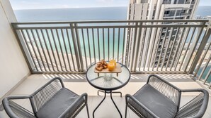 A balcony with a table set for breakfast, overlooking a coastal view. - EDEN'S Homes & Villas - 52/42 Emaar (Dubai)