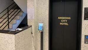 Un ascensor con una pantalla digital y un cartel que indica el Hotel Anseong City.