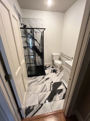 Een bad/douchecombinatie, een haardroger, handdoeken, zeep
