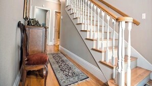 A staircase with white balusters and wooden handrails, leading to an upper floor. - Trailside Manor - 0.5mi from UofA Campus! (Fayetteville)