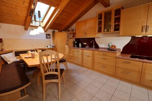 A cozy kitchen with wooden cabinets, a dining table, and a built-in bench.