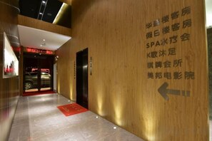 A hotel corridor with directional signage and an elevator.
