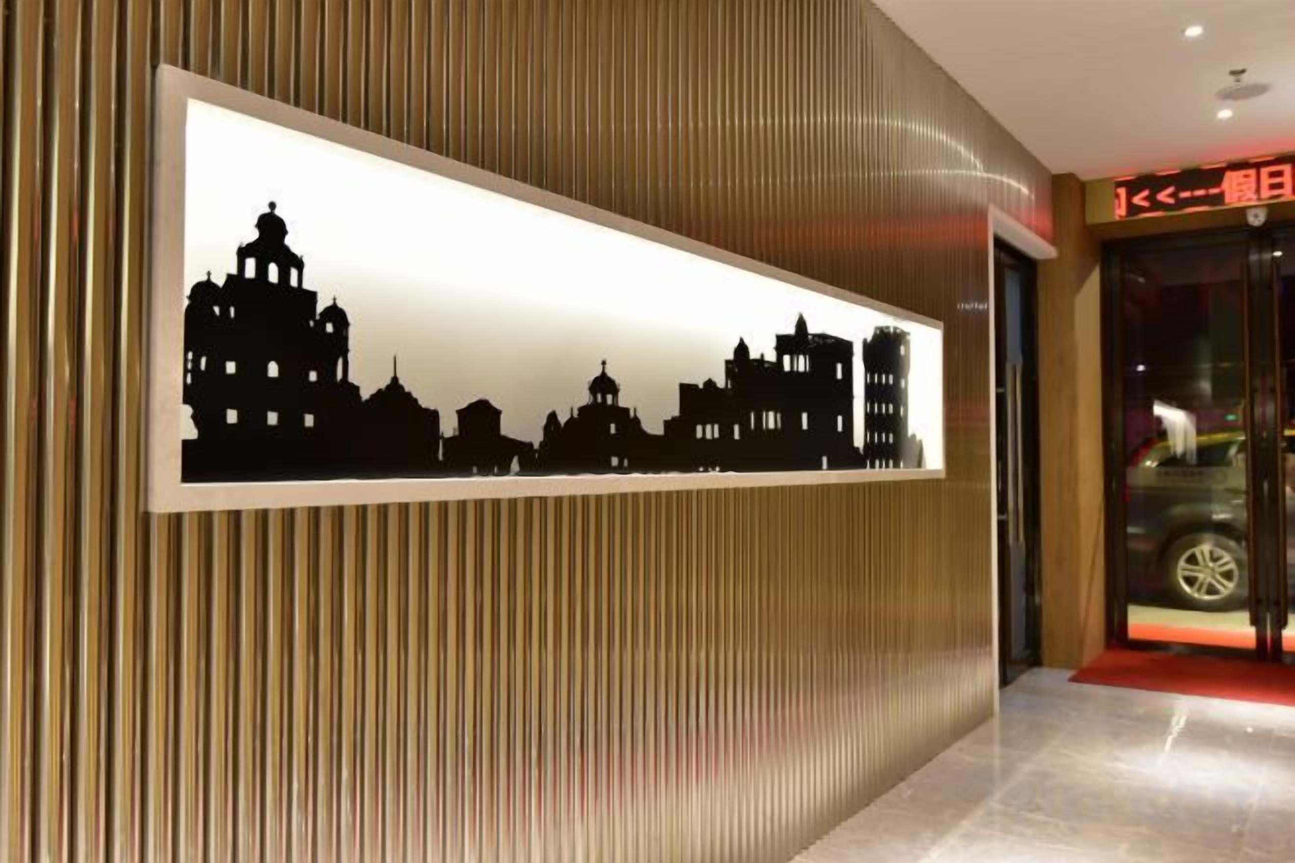 A hotel reception area with a framed silhouette of a city skyline on the wall.