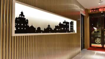 A hotel reception area with a framed silhouette of a city skyline on the wall.
