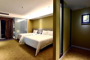 A hotel room with two beds, a large mirror, and a door leading to a bathroom. - Huasheng Holiday Hotel (Kaiping)