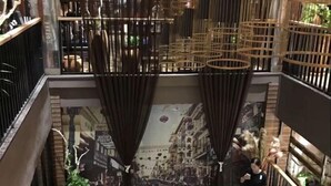 A modern interior with a staircase, wooden railings, and a mural of a city street. - Huasheng Holiday Hotel (Kaiping)