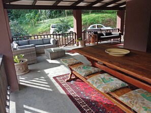 Relax in a serene garden setting with a comfortable seating area featuring a wooden table and benches.