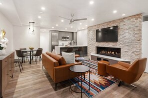 Un salon moderne doté d’une cheminée, d’un coin repas et d’une cuisine.