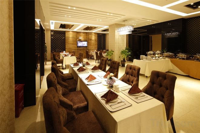 Une salle de conférence équipée d’une longue table, de nombreuses chaises et d’un espace buffet.