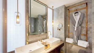 A modern bathroom with two sinks, a large mirror, and a robe rack.