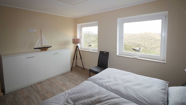 A bedroom with two beds, a desk, a chair, and two windows. - 107-3 Holiday apartment Klabautermann - 107-3 Klabautermann (Juist)