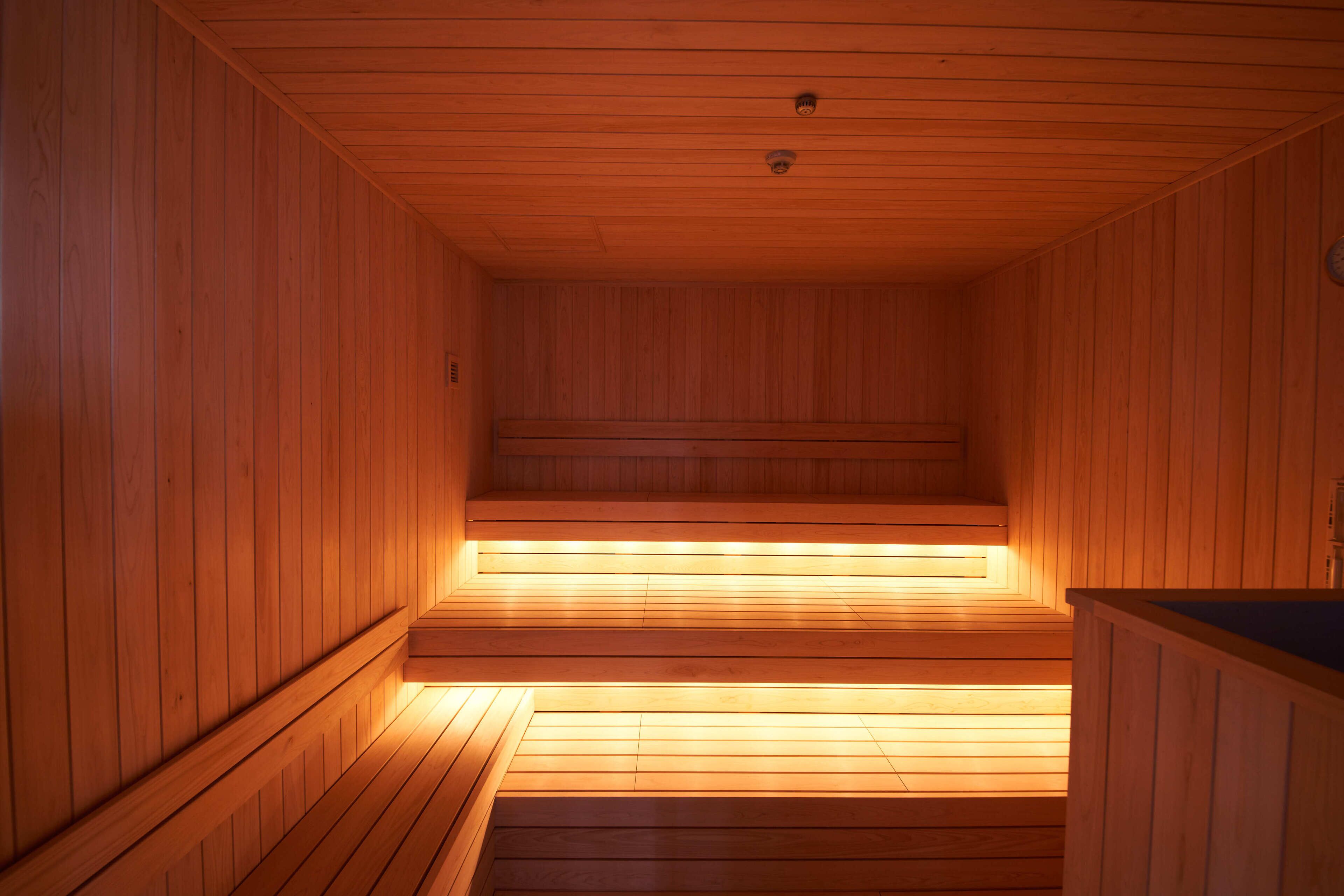 A wooden sauna with benches and a bench on the right.