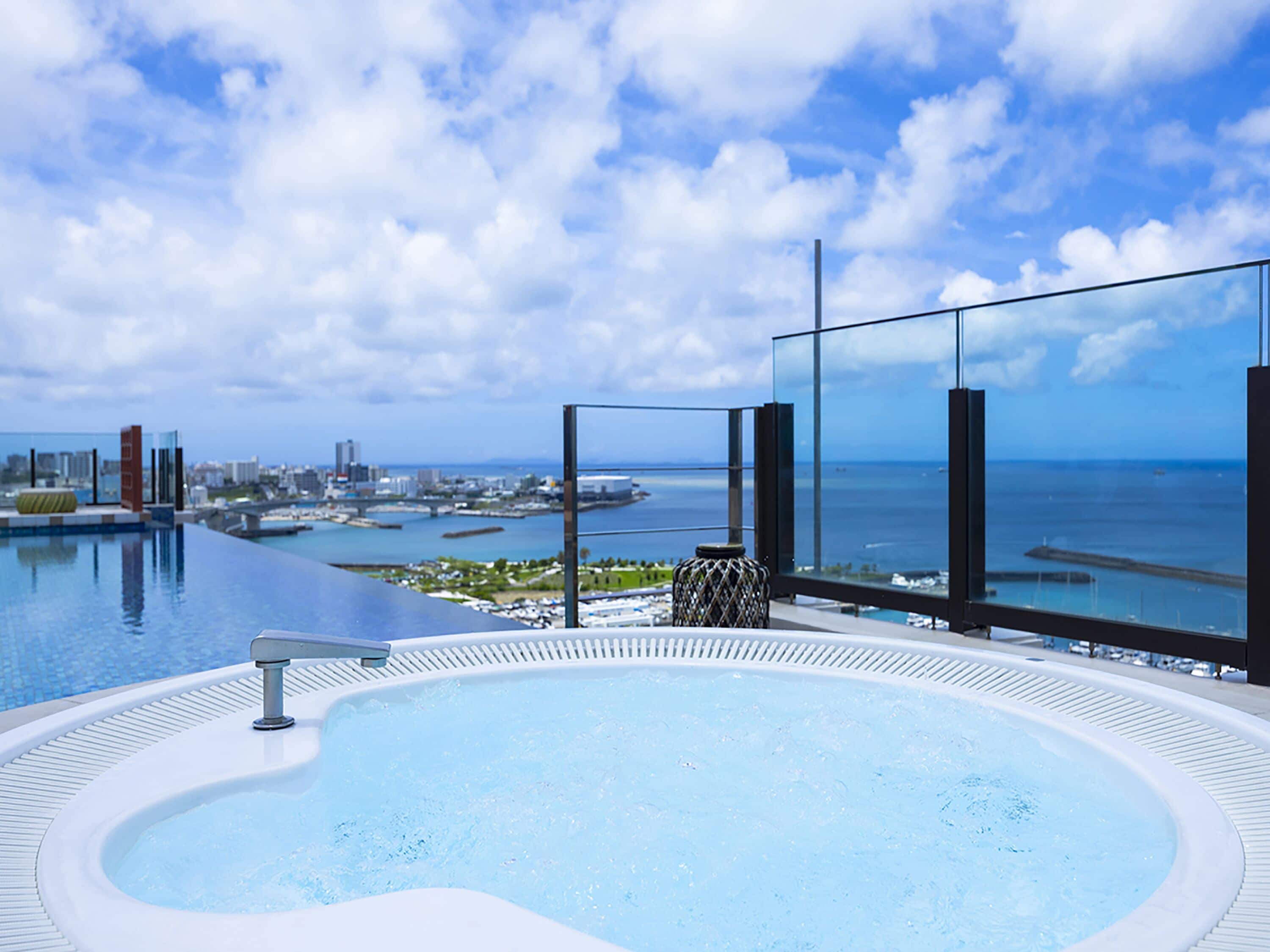 Ein Pool mit unendlicher Weite auf dem Dach, mit Blick auf das Meer und die Skyline der Stadt.