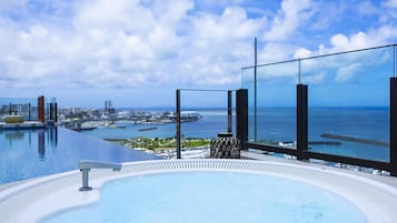 Piscina infinita no terraço com vista deslumbrante para o oceano e o horizonte da cidade.