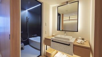 A modern bathroom with a walk-in shower, a large mirror, and a wooden vanity.