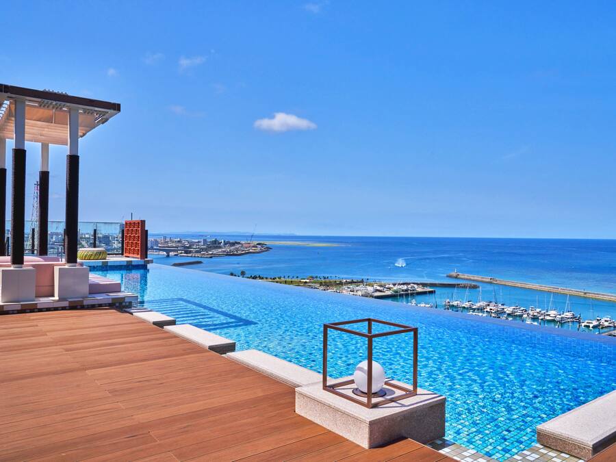 A luxurious infinity pool with a clear view of the ocean and marina.