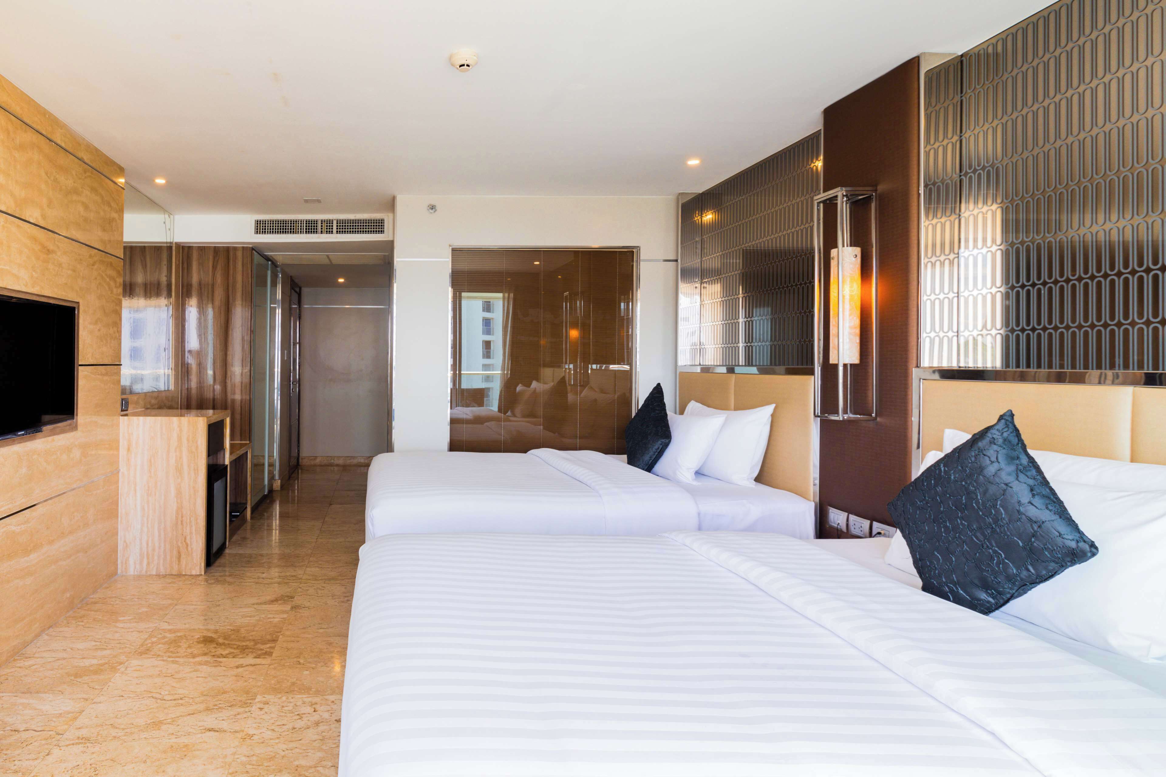 Une chambre d’hôtel avec deux lits, une télévision et un minibar.