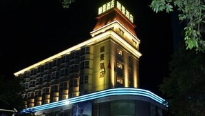 Um hotel com uma placa grande no topo, vários andares e um design moderno.
