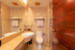 A modern bathroom with a large mirror, a sink, a toilet, and a shower area. - Shunjing Hotel (Zhongshan)