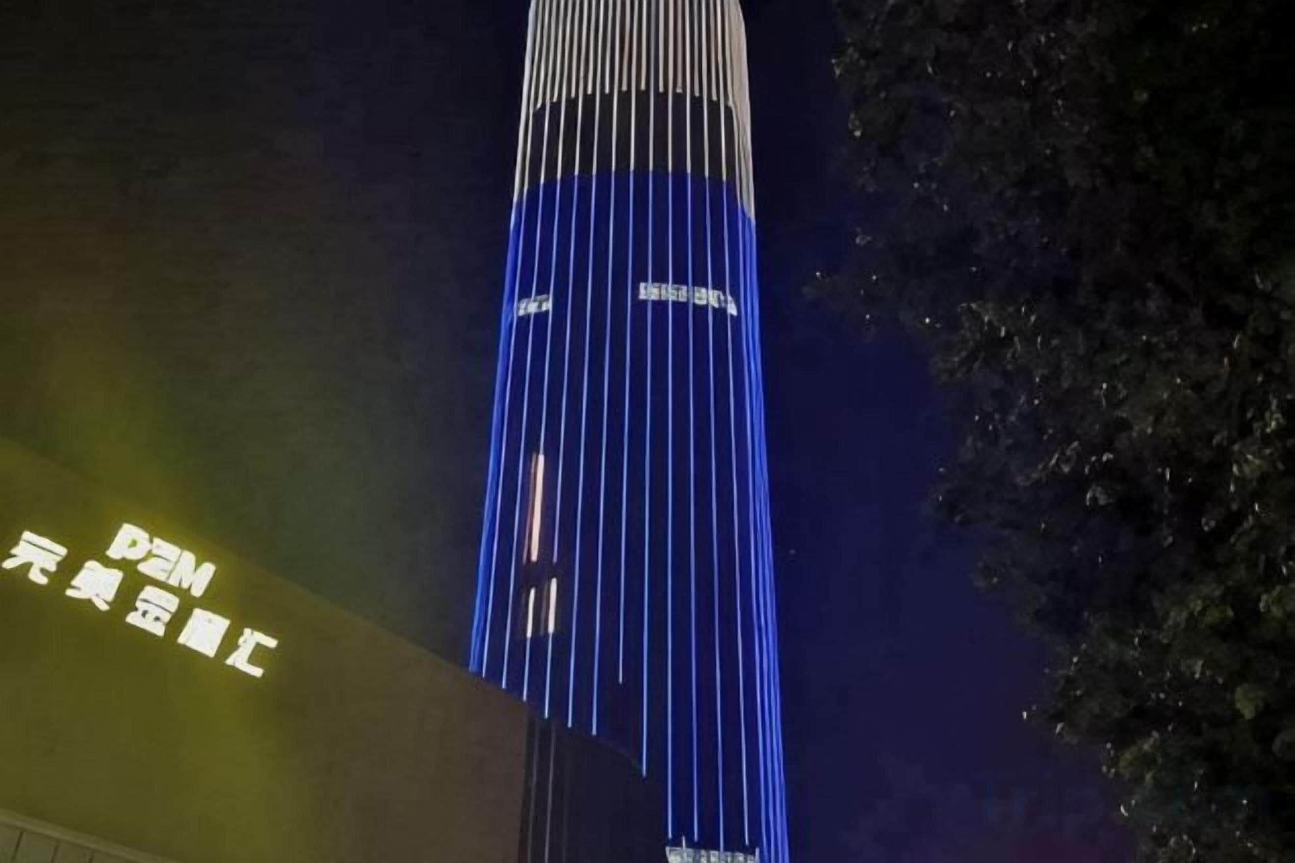 A tall building with vertical lines of light.