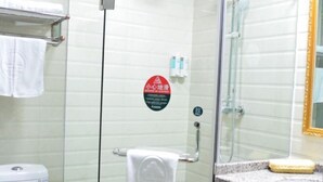 A bathroom with a glass shower enclosure, a towel rack, and a sink with a soap dish.