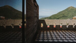 A room with a checkered floor, wooden walls, and a view of a mountain. - Mountain Traveler Inn (New Taipei City)