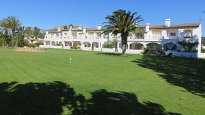 A white building with multiple balconies and a well-maintained lawn. - Apartment 'Les Fonts 83' with Shared Pool, Private Terrace and Balcony (L'Estartit)