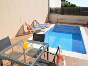 A rooftop pool area with a glass table, chairs, and a tiled floor. - Villa "Medas Maura 8" with Pool, Wi-Fi, Balcony and Terrace (L'Estartit)
