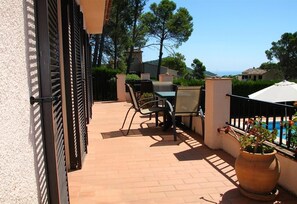 Un patio con muebles de exterior, piscina y vista al mar.
