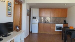 A compact kitchen with a refrigerator, microwave, sink, and stove. - Apartments Miami II 307 with Mountain View, Pool, Wi-Fi & Garden (L'Estartit)