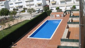 A rectangular swimming pool with a tiled deck, surrounded by a low hedge and a paved walkway. - Apartments Miami II 307 with Mountain View, Pool, Wi-Fi & Garden (L'Estartit)