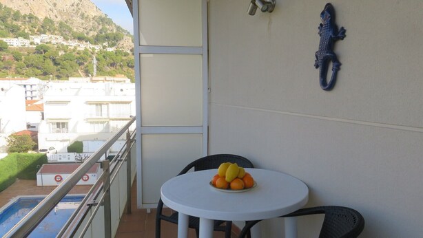 A balcony with a table, chairs, and a bowl of fruit. - Apartments Miami II 307 with Mountain View, Pool, Wi-Fi & Garden (L'Estartit)