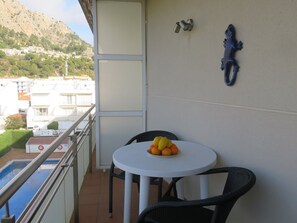 Ein Balkon mit Tisch, Stühlen und einer Obstschale.