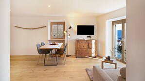 Un espacio habitable moderno con comedor, televisor y vistas al exterior.