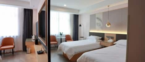 A hotel room with two beds, a desk, a chair, and a window.