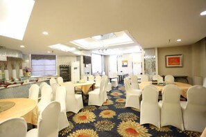 A conference room with round tables, white chairs, and a patterned carpet. - Guyang Hotel (Guzhen)