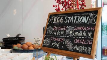 A chalkboard menu at an egg station with options like poached, sunny side up, scrambled, and omelette.
