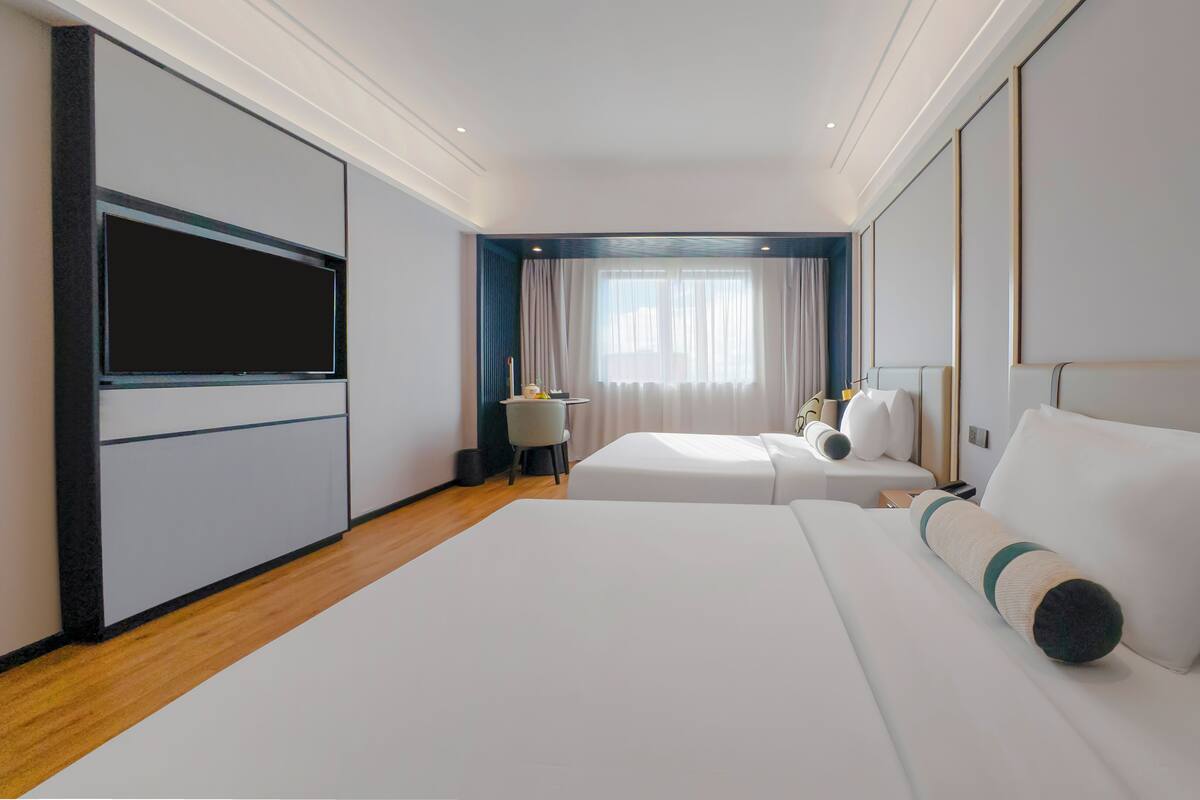Een hotelkamer met een groot bed, een bureau, een stoel en een televisie.