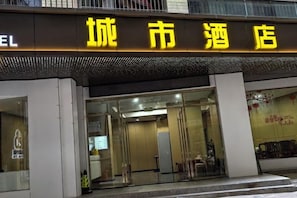 A hotel entrance with a sign in yellow characters, a glass door, and a visible interior with tables and chairs. - Super 8 Lechang Shaoguan Renmin Middle Road (Lechang)